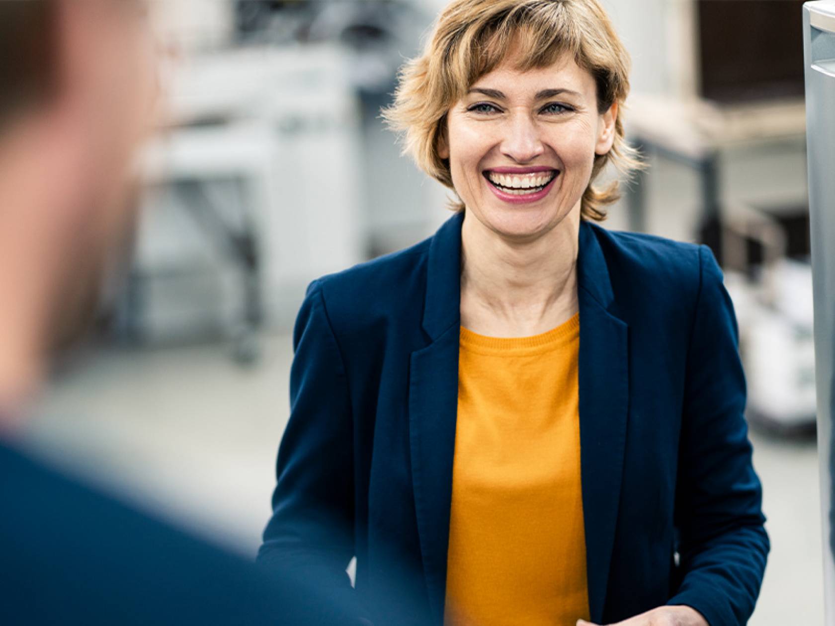 Wiki Schmuckbild Frau mit orangenem Oberteil lacht