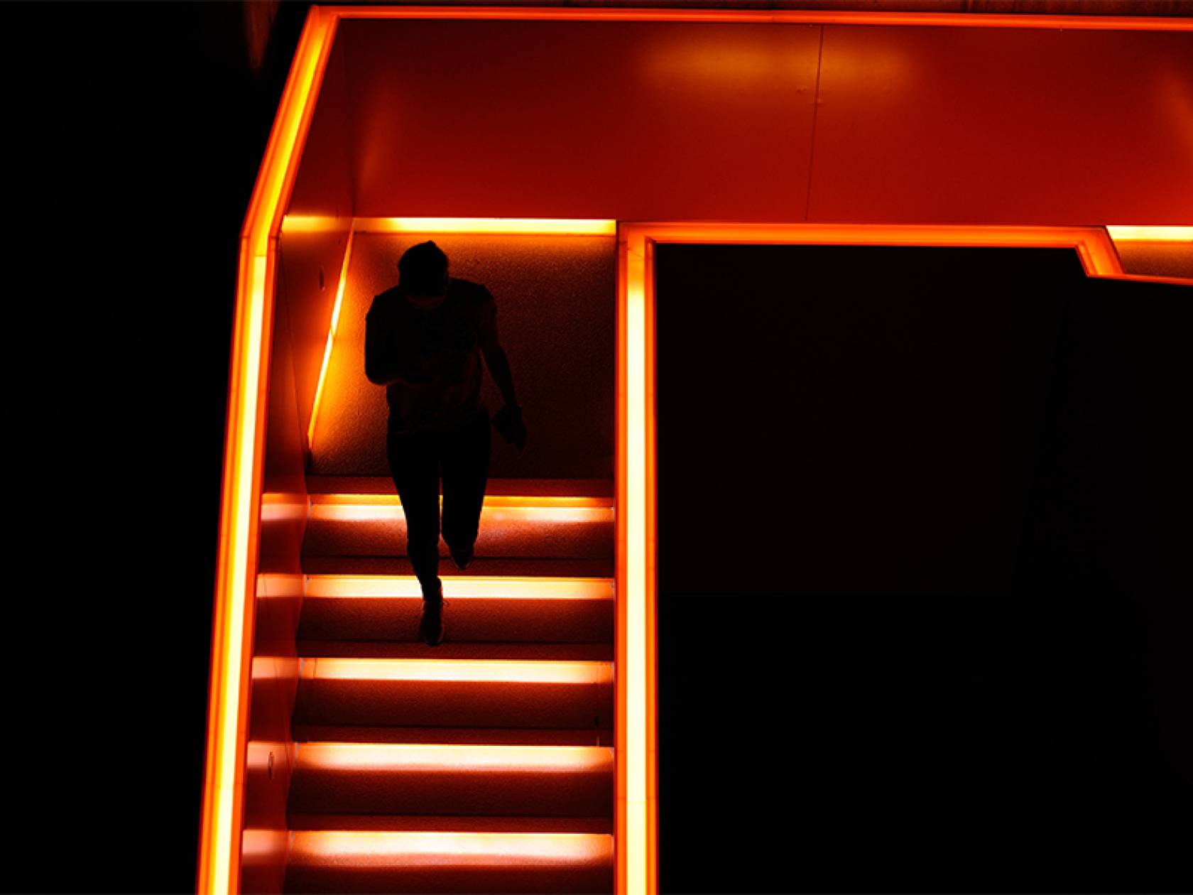 Wiki Schmuckbild 13 Ein Mensch läuft eine hell erleuchtete Treppe hinauf